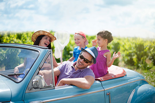 Family in car in lush outdoor scene